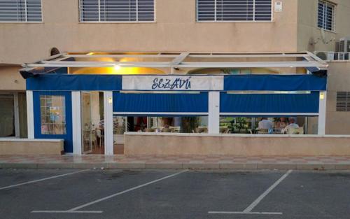 a store with a blue awning in front of a building at Preciosa Casita Boho Chic en la playa in Gran Alacant