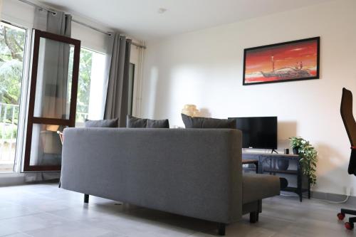 un salon avec un canapé et une télévision dans l'établissement Splendide Appartement - Chevilly-Larue Paris Orly, à Chevilly-Larue
