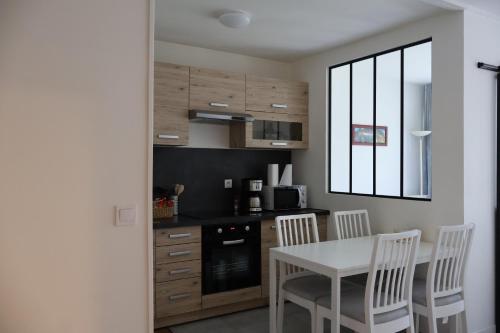 une cuisine avec une table et des chaises et une cuisine avec une fenêtre dans l'établissement Splendide Appartement - Chevilly-Larue Paris Orly, à Chevilly-Larue
