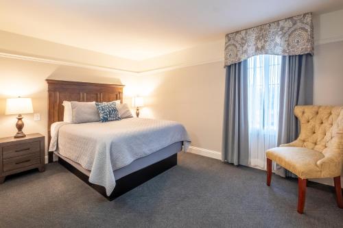a bedroom with a bed and a chair at Red Coach Inn in Niagara Falls