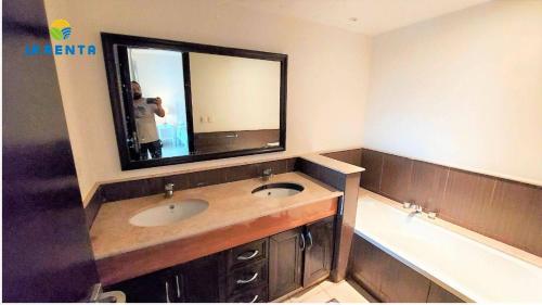 ein Badezimmer mit Waschbecken, Spiegel und Badewanne in der Unterkunft Apartment for rent in Dawwār Abū Maḩrūs