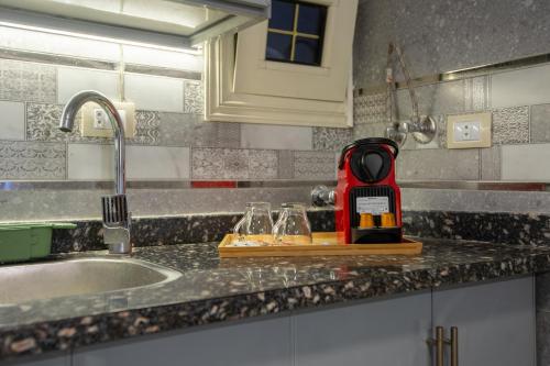 a kitchen counter with a red appliance on a cutting board at Skyline Premium Properties in Alexandria