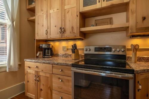 a kitchen with wooden cabinets and a stove at The Downtown Lovely in Livingston