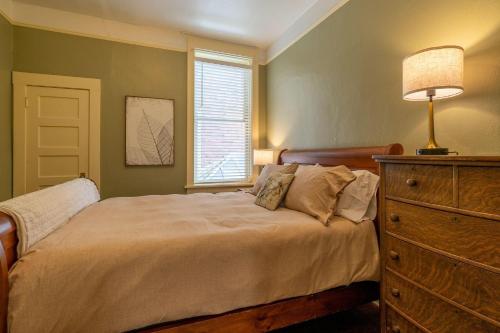 a bedroom with a bed with a dresser and a window at The Downtown Lovely in Livingston