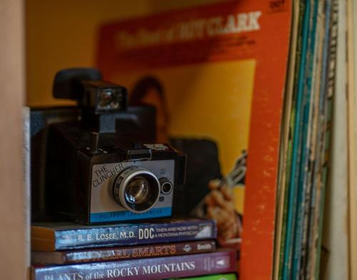 a camera sitting on top of a stack of books at The Downtown Lovely in Livingston