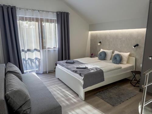 a bedroom with a bed and a large window at Heaven Apartment in Hajdúszoboszló