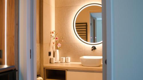 ein Badezimmer mit Waschbecken und Spiegel in der Unterkunft Baltic Hideaways Beach Hotel Warnemünde in Warnemünde