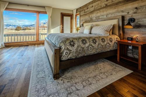 a bedroom with a bed and a large window at Osprey Acres in Emigrant