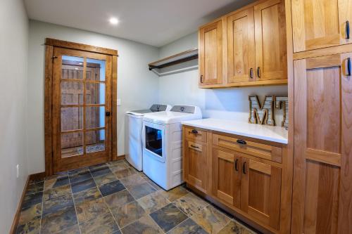 a kitchen with a washer and dryer and wooden cabinets at Osprey Acres in Emigrant