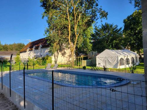 une clôture autour d'une piscine avec une tente dans l'établissement A proximité du zoo de beauval, chambre de charme 