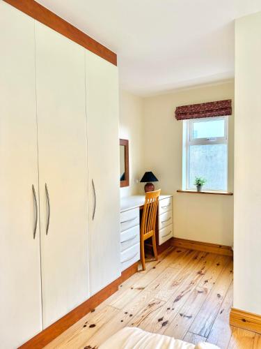 a bedroom with white cabinets and a desk at No 10 Ard Na Mara in Dingle