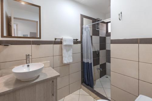 a bathroom with a sink and a mirror at Pacific Sunset Ground Unit Condo Across The Beach in Coco