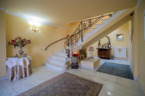 un salon avec un escalier avec une table et un tapis dans l'établissement Villa Marchese, à Trecastagni