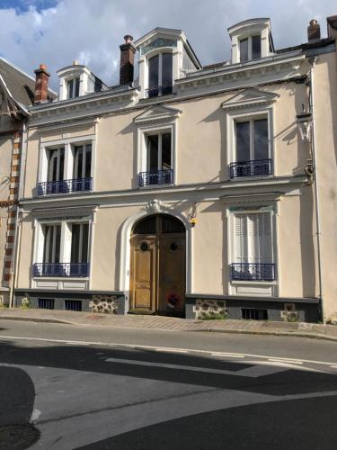 une maison blanche avec une porte en bois dans une rue dans l'établissement Appartement - Urban - entre Disney et Paris, à Lagny-sur-Marne