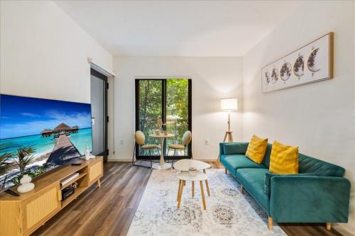 a living room with a green couch and a table at Cozy 1BR apt in Hollywood w Pool, Gym and Parking in Los Angeles