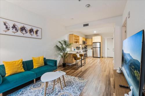 a living room with a green couch and a table at Cozy 1BR apt in Hollywood w Pool, Gym and Parking in Los Angeles