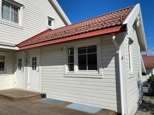 a small white building with a red roof at Newly renovated studio apartment - free parking and EV docking in Trondheim