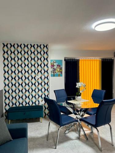 a dining room with a table and blue chairs at Iris Chic Residence in Marsaskala