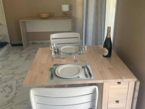 - une table avec deux assiettes et une bouteille de vin dans l'établissement Studio AC with Balcony by Olidesi, à Cannes