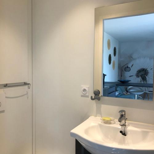 une salle de bain avec un lavabo et un miroir dans l'établissement My cosy mobil-home, à Saint-Quentin-la-Poterie