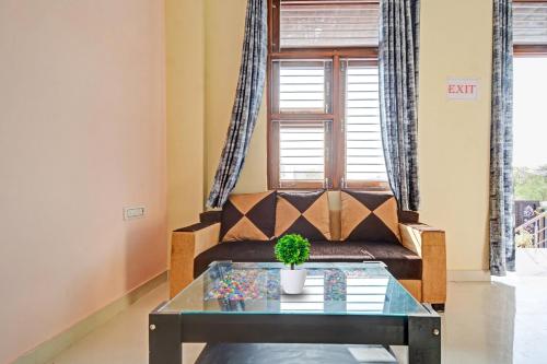 a living room with a couch and a table at Hotel O Kalot in Jaipur