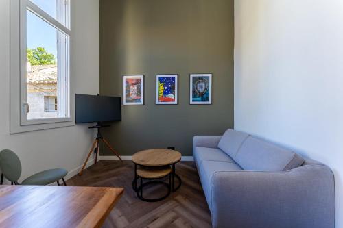 un salon avec un canapé bleu et une table dans l'établissement Duplex Bénézet - Welkeys, à Avignon
