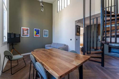 un salon avec une table et des chaises en bois dans l'établissement Duplex Bénézet - Welkeys, à Avignon