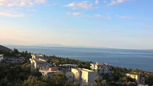 a group of buildings on a hill next to the water at Oriente Sole in Dhërmi