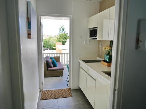a kitchen with white cabinets and a view of a balcony at 4BlessingsCuracao1 in Willemstad