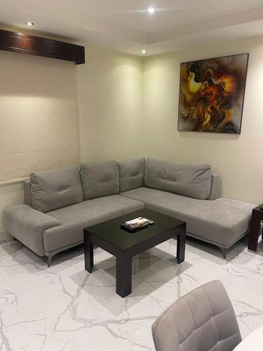 a living room with a couch and a coffee table at أول سويت للشقق المخدومة in Riyadh