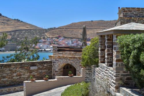a stone building with a brick archway with buildings in the background at KEOS by the sea in Korissia