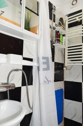 een badkamer met een wastafel en een douchegordijn bij YNA House in Boekarest