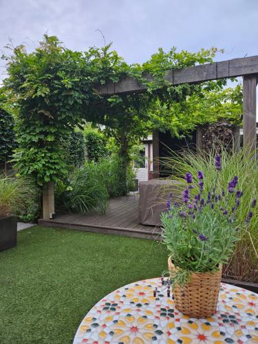 a garden with a table with a potted plant on it at B&B Schiphol Amsterdam in Rijsenhout