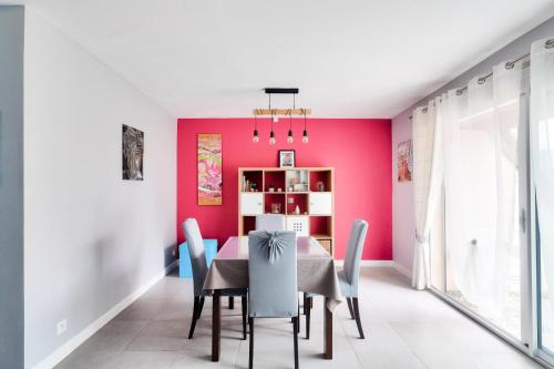 une salle à manger aux murs roses avec une table et des chaises dans l'établissement Résidence Villers 2000 - Maeva Home - Appartement 3 pièces 4 personnes - Sélection MAE-5631, à Villers-sur-Mer