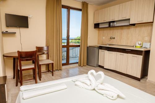 a room with a kitchen and a table with towels at Family Hotel Silitur in Ahtopol