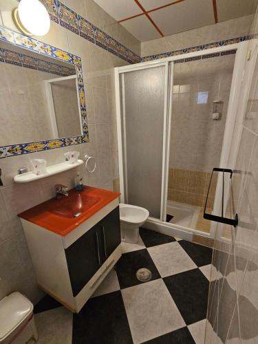 a bathroom with a sink and a toilet and a shower at Hostal Sevillana Costa in Chipiona