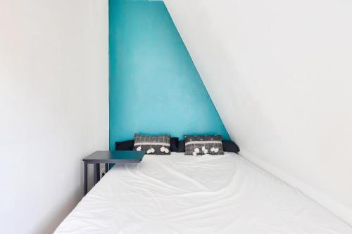 un lit dans une chambre avec un mur bleu dans l'établissement Résidence Le Deauville - Maeva Home - Appartement 2 pièces 4 personnes - Sélection MAE-9081, à Villers-sur-Mer