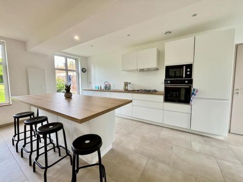 a kitchen with white cabinets and a wooden counter top at Gîte des 6 tilleuls in Bomy