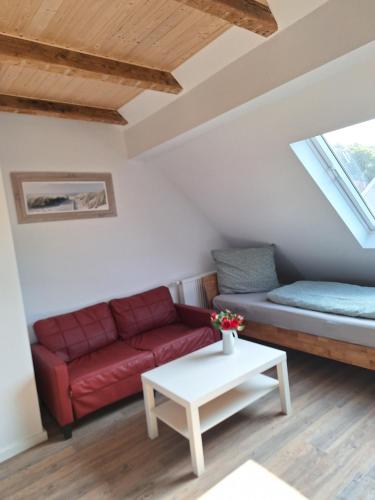 a living room with a red couch and a table at Fleute in Emden