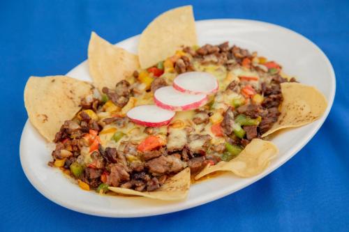 a white plate of food with a plate of tacos at Hotel Hacienda María Eugenia Acapulco in Acapulco