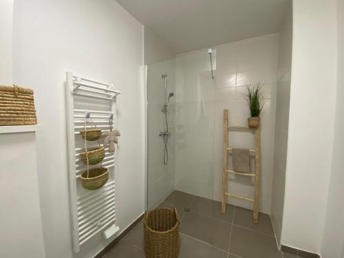 a white bathroom with a shower and a basket at Villa Cano Beach in Lacanau-Océan