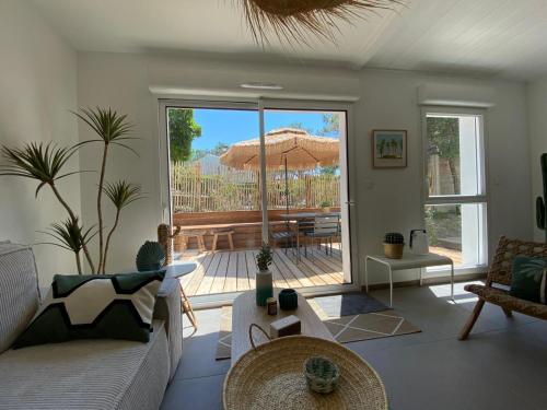 - un salon avec un canapé et un parasol dans l'établissement Villa Cano Beach, à Lacanau-Océan