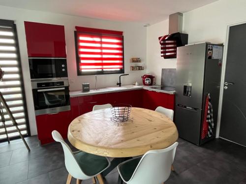- une cuisine avec une table en bois et des chaises blanches dans l'établissement maison individuelle proche Chenonceau et Amboise, à La Croix-en-Touraine