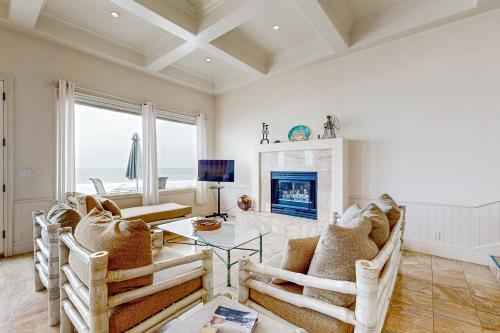 a living room with a table and chairs and a fireplace at Breakers Way Dream in Carpinteria