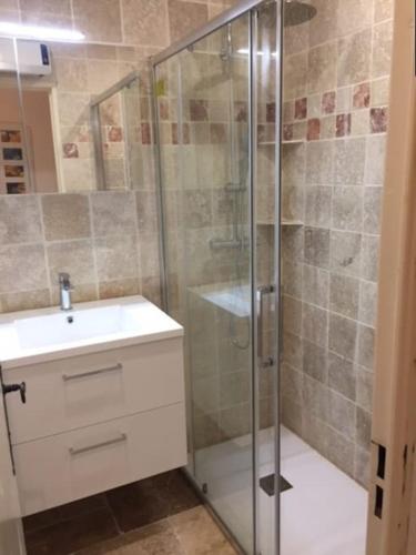 une salle de bain avec une douche en verre et un lavabo dans l'établissement Appartement climatisé 4 personnes dans une résidence avec piscine, à Cavalaire-sur-Mer