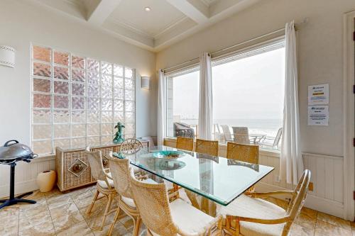 a dining room with a glass table and chairs at Breakers Way Dream in Carpinteria