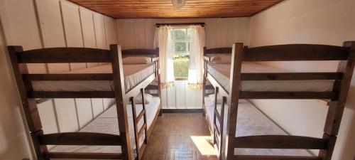 una habitación con tres literas y una ventana en Casa Violeta, en Campos do Jordão
