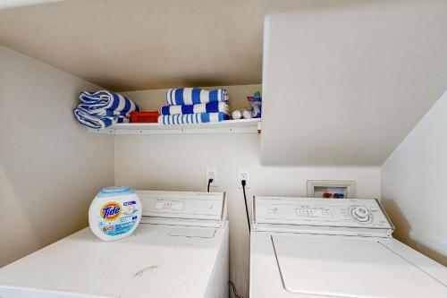 a laundry room with a washing machine and a shelf at Breakers Way Dream in Carpinteria