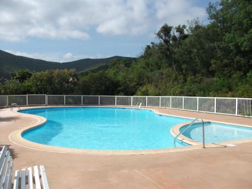une grande piscine bleue avec des montagnes en arrière-plan dans l'établissement Appartement climatisé 4 personnes dans une résidence avec piscine, à Cavalaire-sur-Mer