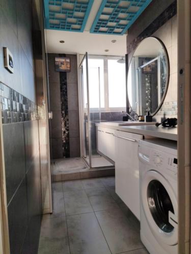La salle de bains est pourvue d'un lave-linge et d'un miroir. dans l'établissement Appart vu panoramique Marseille, à Marseille